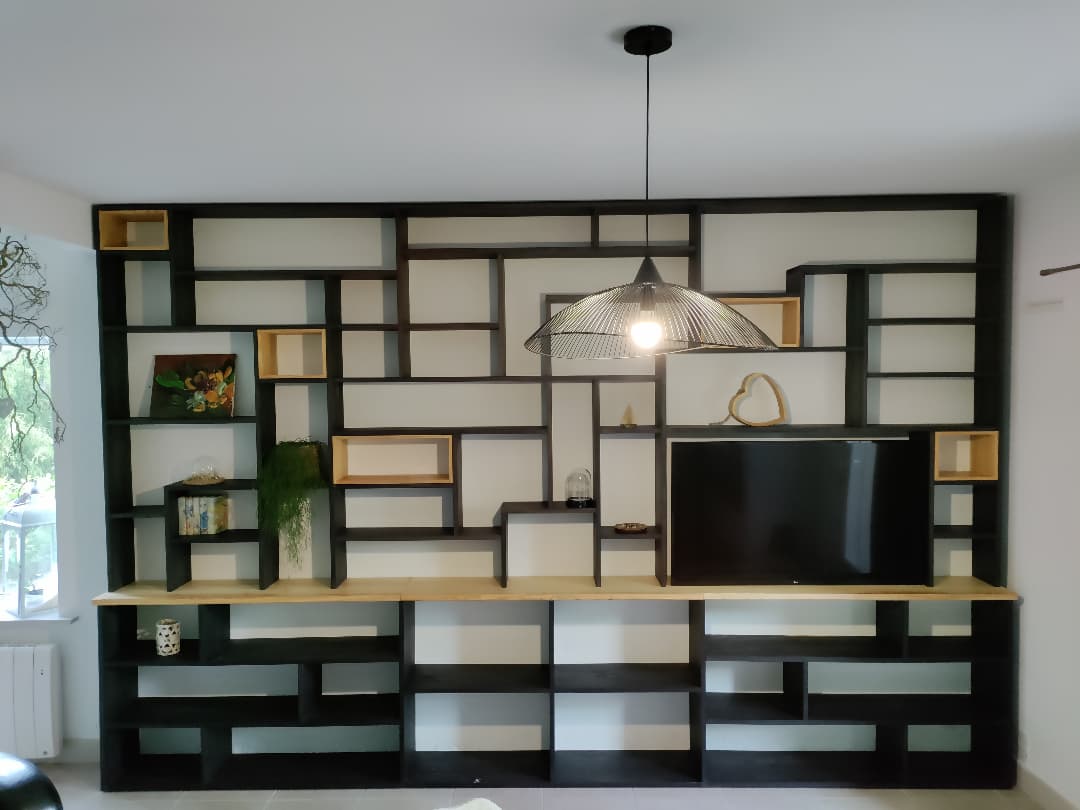Cabinet de curiosités en frêne teinté. Cases éparses en frêne clair. Finition à l'huile-cire. 